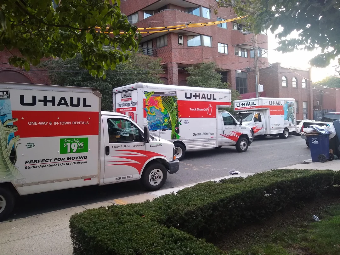 Three moving trucks on a street in Boston